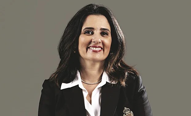 Studio portrait of Lamia Tazi in a black blazer against a dark background