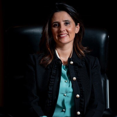 Lamia Tazi photographed seated in a dark executive chair